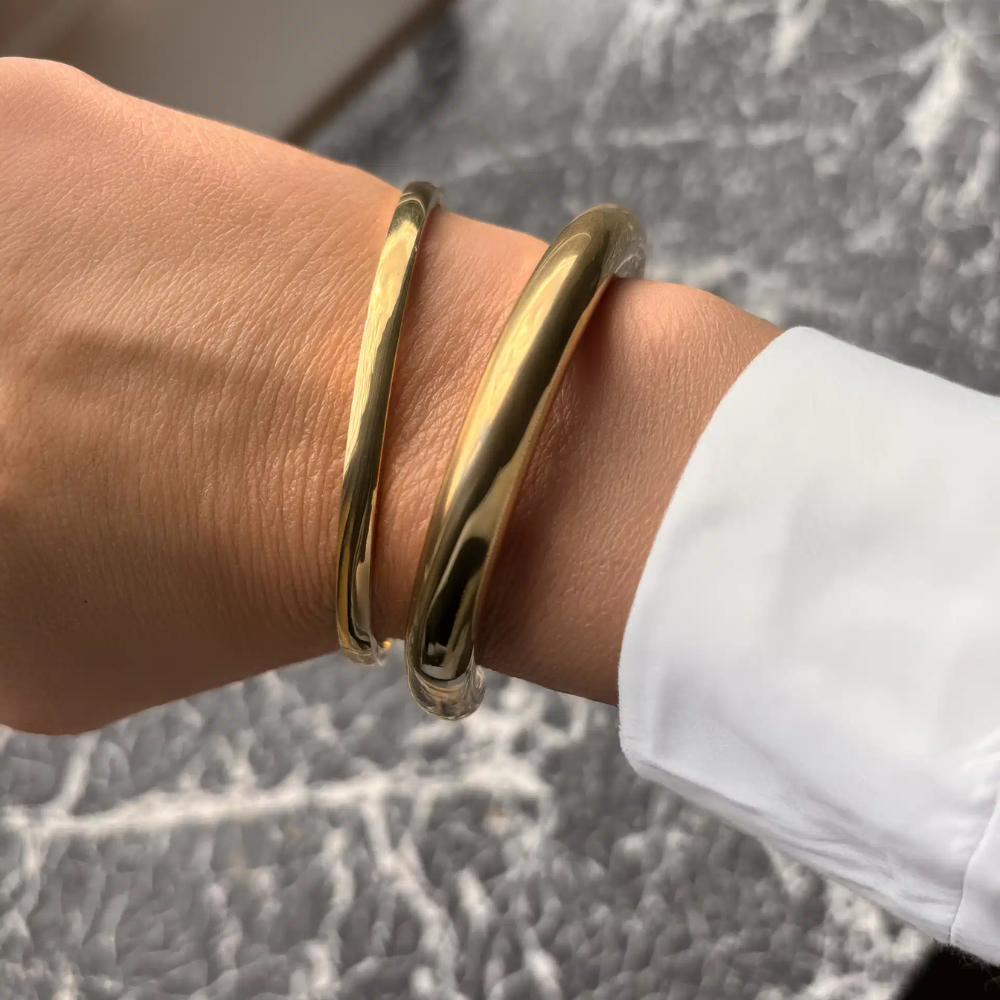 Molly - Oval armring med klik lås i guldfarvet stål - st60002