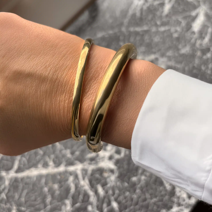Molly - Oval armring med klik lås i guldfarvet stål - st60002
